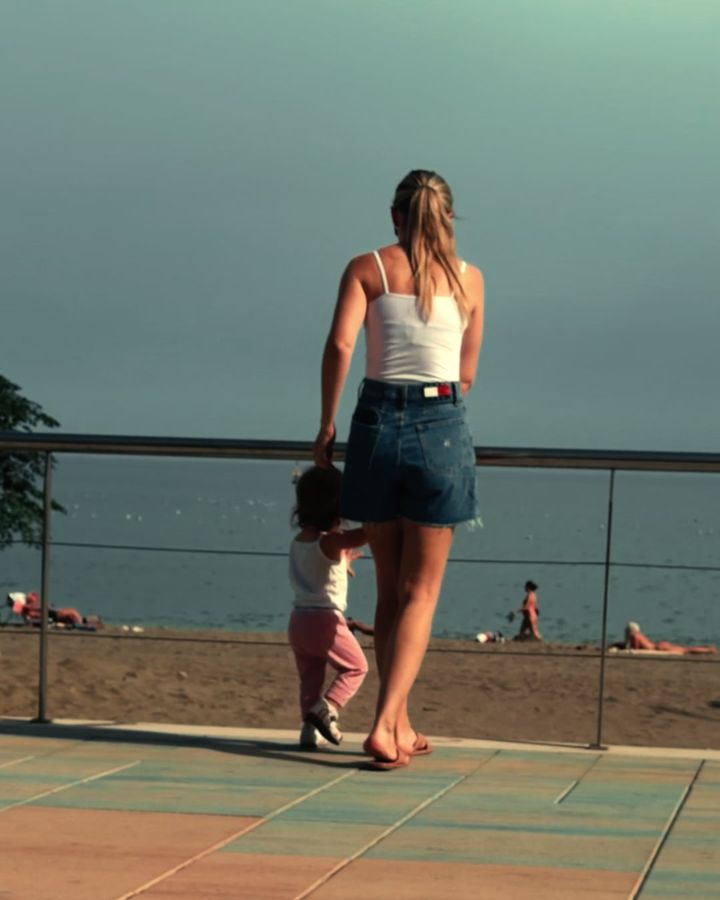 Manželka s dcérou zozadu na promenáde pri mori